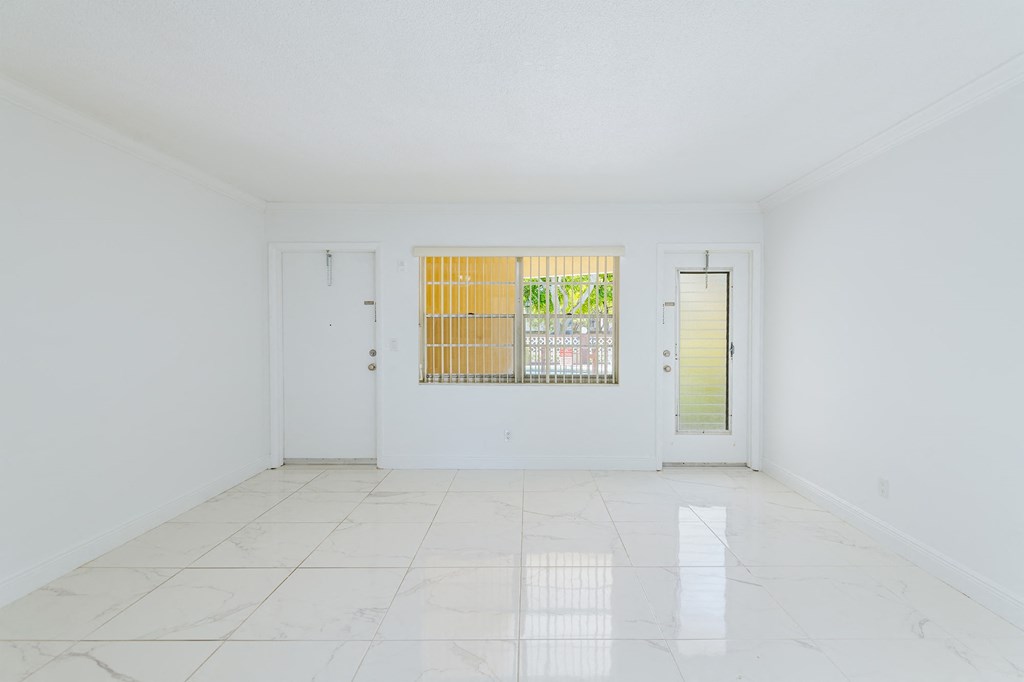 an empty living room with white walls and a window