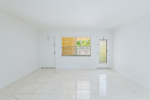 an empty living room with white walls and a window