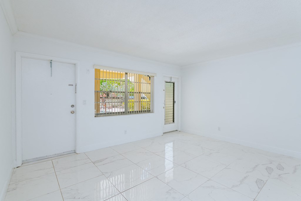 an empty living room with white walls and white marble floors