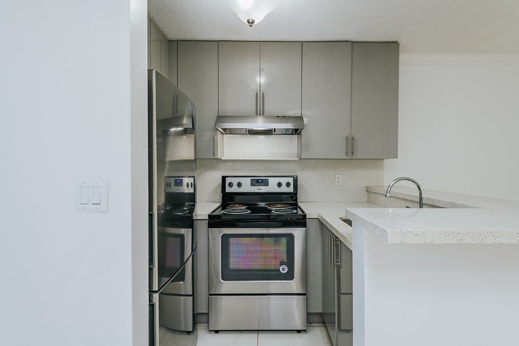 a kitchen with stainless steel appliances and a white counter top