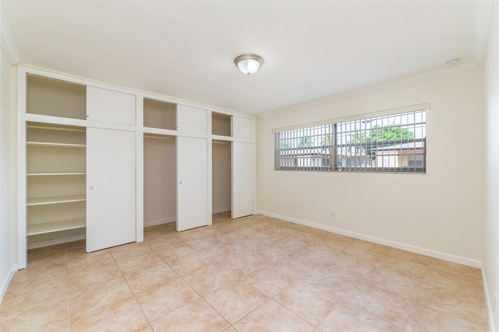 an empty living room with white closets and a window