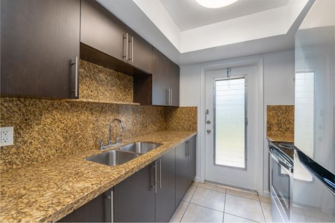 a kitchen with a sink and a counter with a door