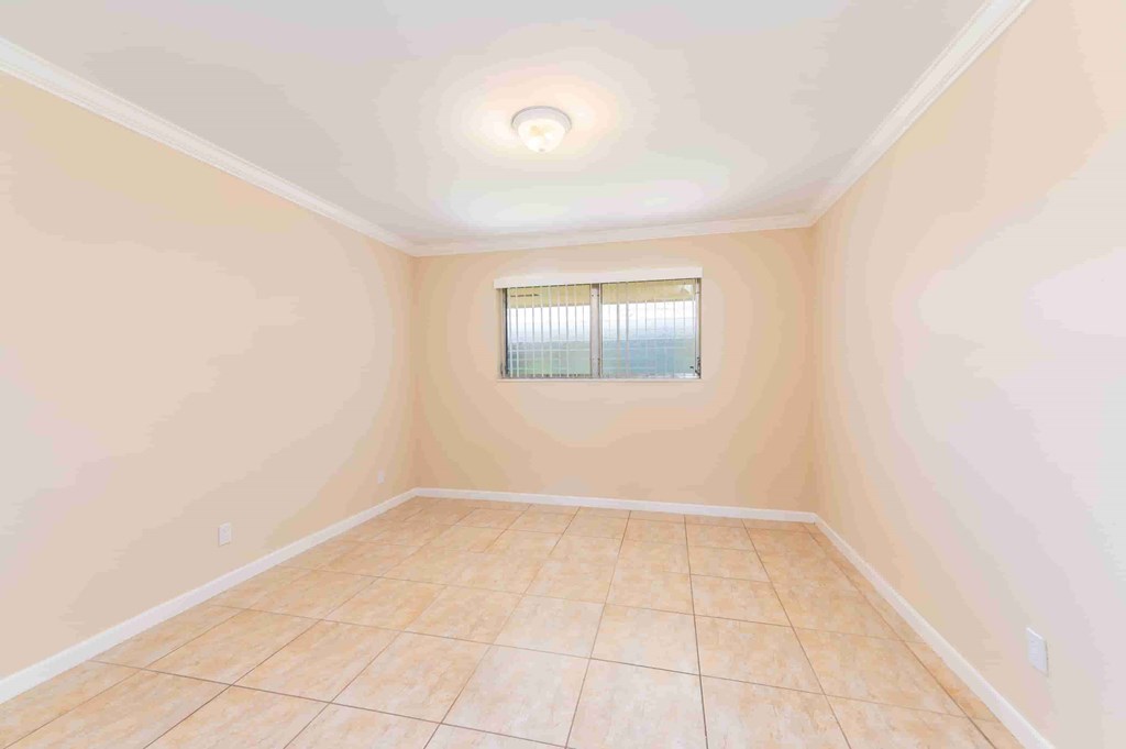 an empty room with tiled floors and a window