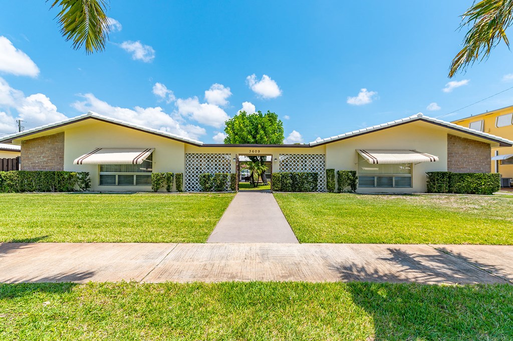 a house with a lawn and a sidewalk in front of it