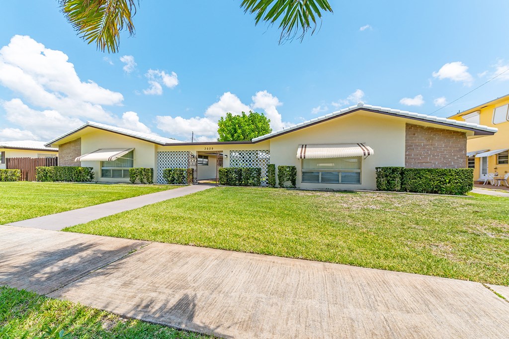 a house with a yard and a sidewalk in front of it