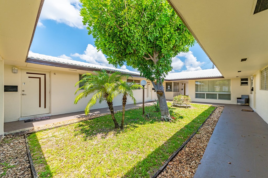 a yard with palm trees and a house
