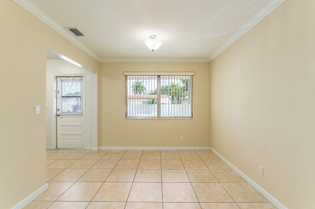 an empty living room with a window and a door