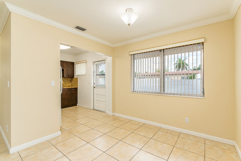 a kitchen with a large window and a tiled floor
