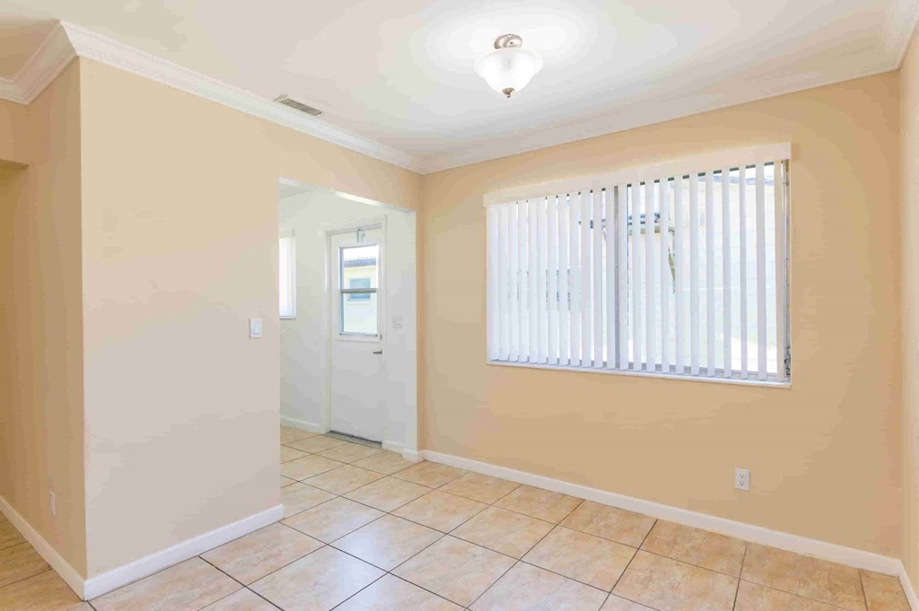 a living room with a large window and a tiled floor