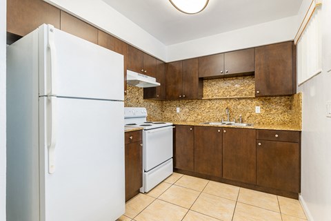 a kitchen with white appliances and brown cabinets and a white refrigerator