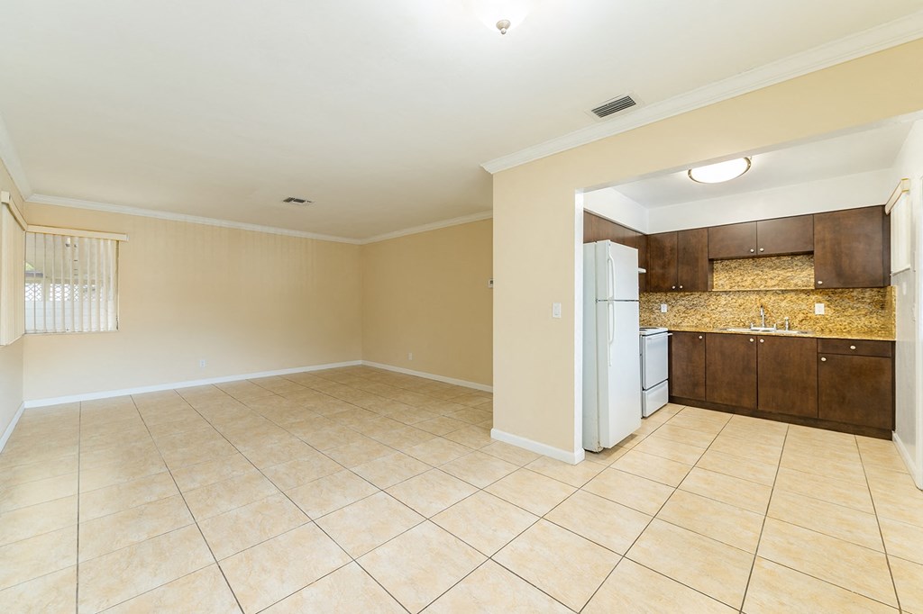 a kitchen and living room with a white refrigerator