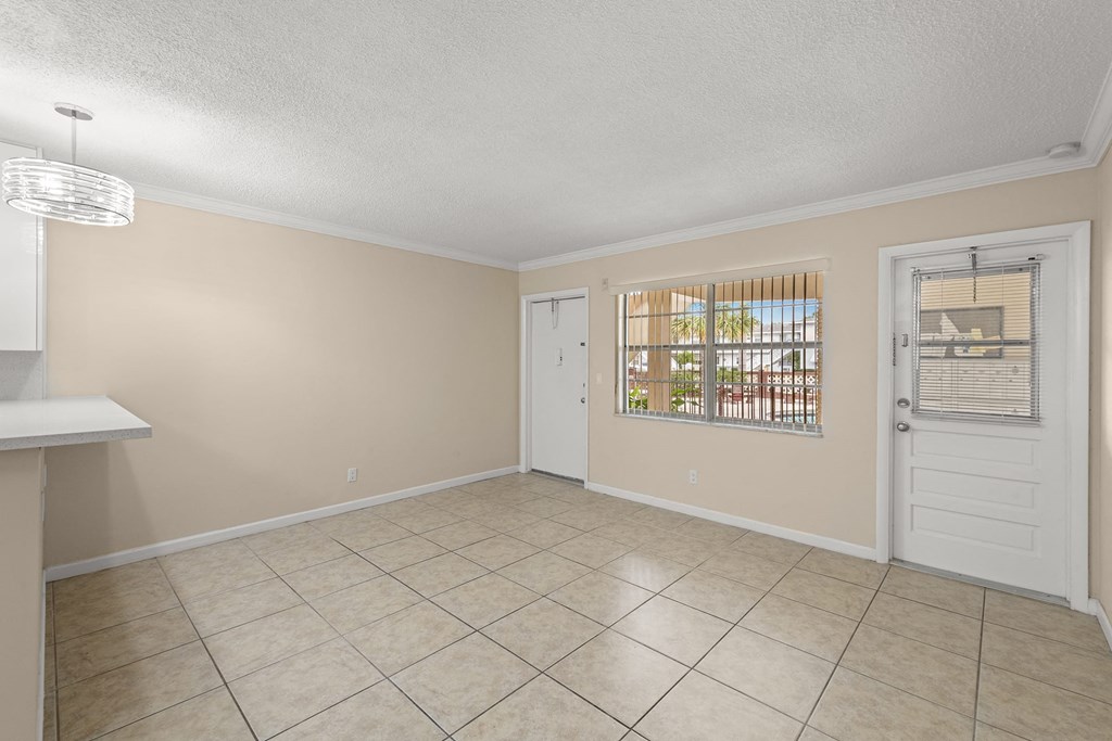 a living room with a white door and a tiled floor