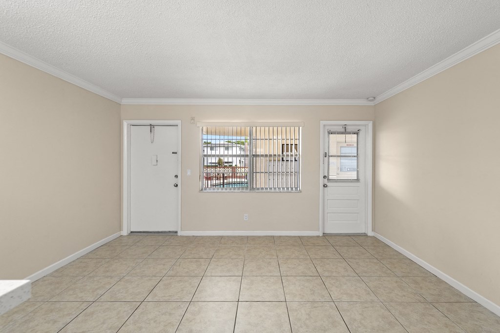 the living room of a house with a door and a tiled floor