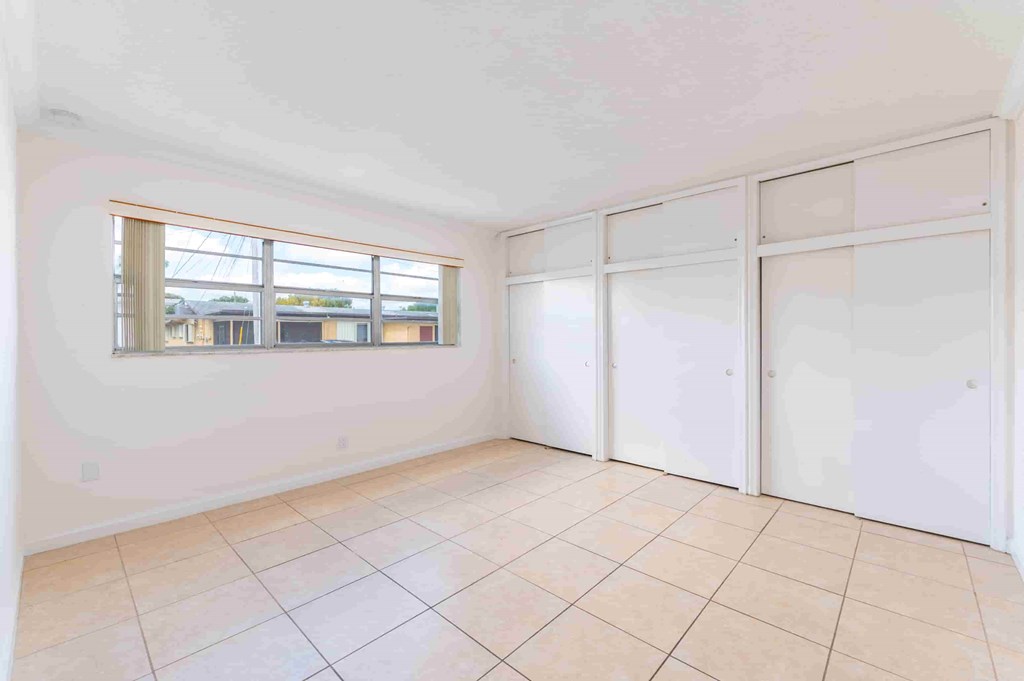 an empty living room with white walls and a window