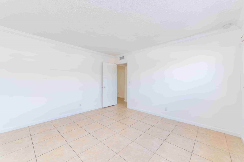 an empty room with a tile floor and white walls