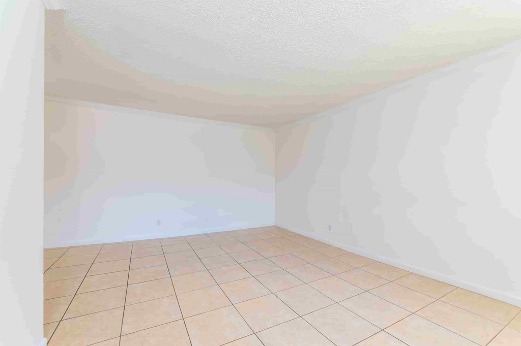 an empty room with white walls and a tiled floor