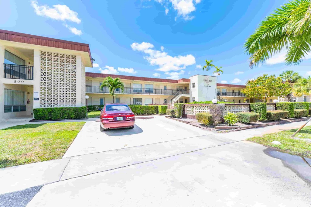a red car parked in front of an apartment building