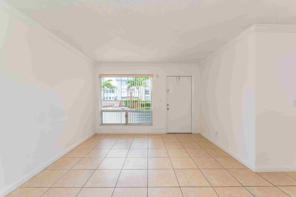 a living room with a tile floor and a door to a balcony