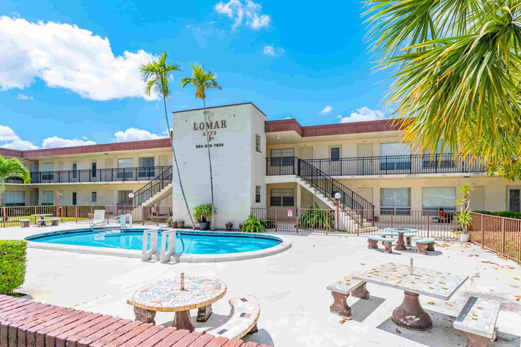 a view of the luana inn with a pool and palm trees