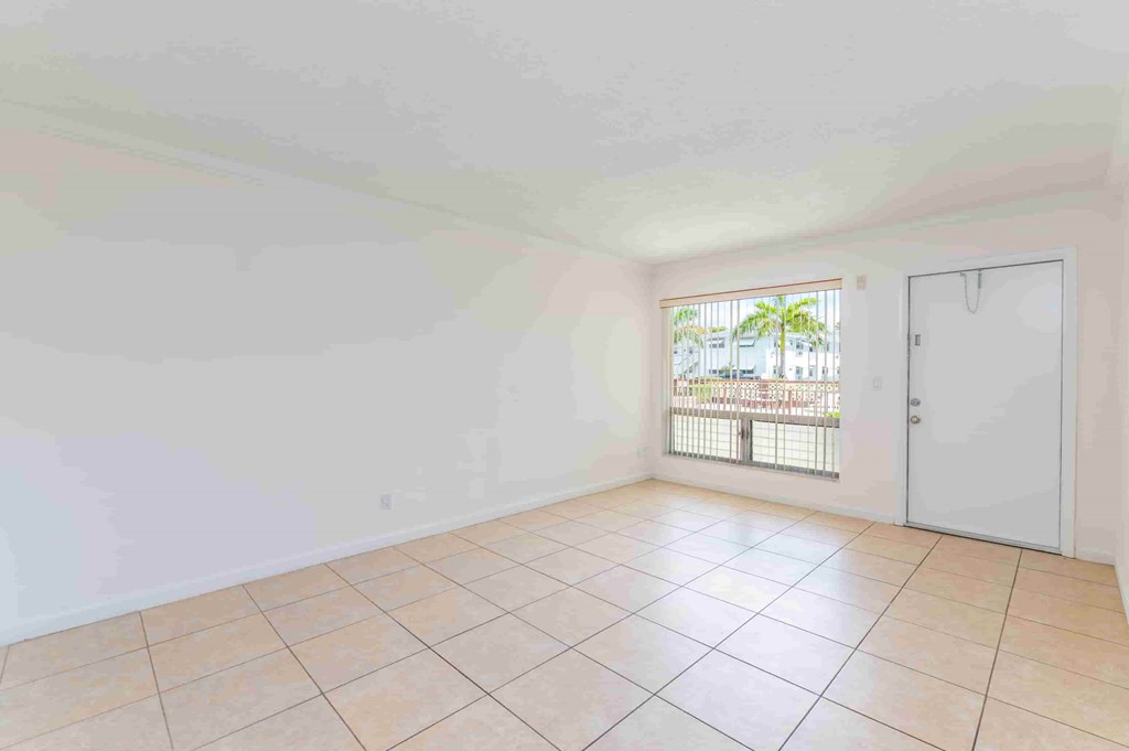 an empty living room with a door to a patio