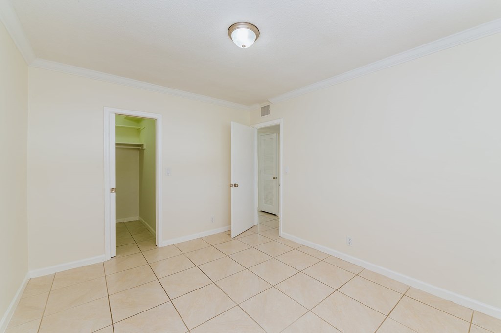 a room with a tiled floor and a door to a hallway