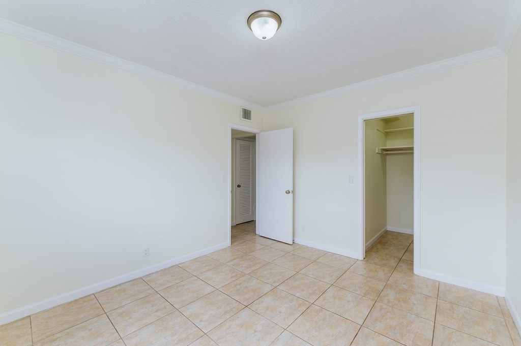 an empty room with a tile floor and a closet