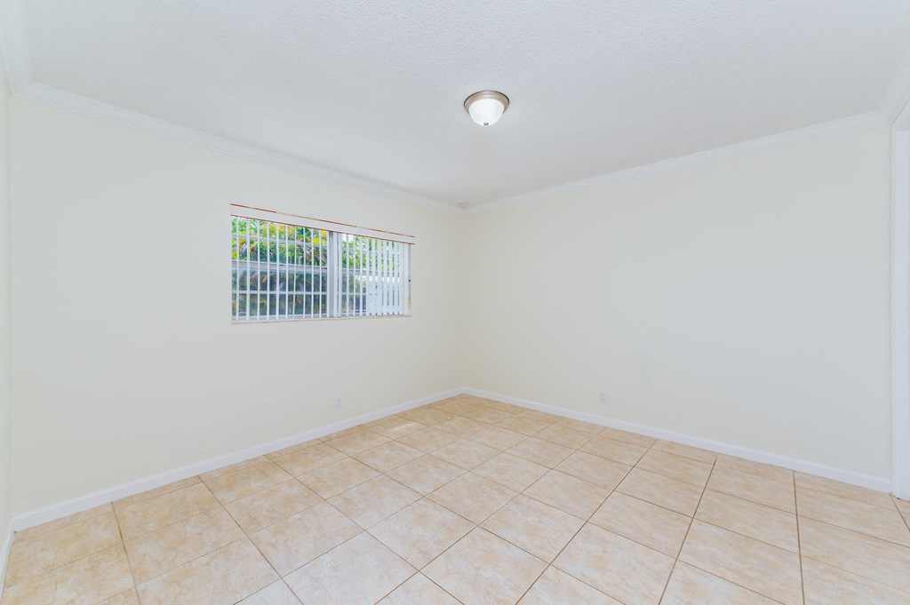 an empty living room with tile flooring and a window