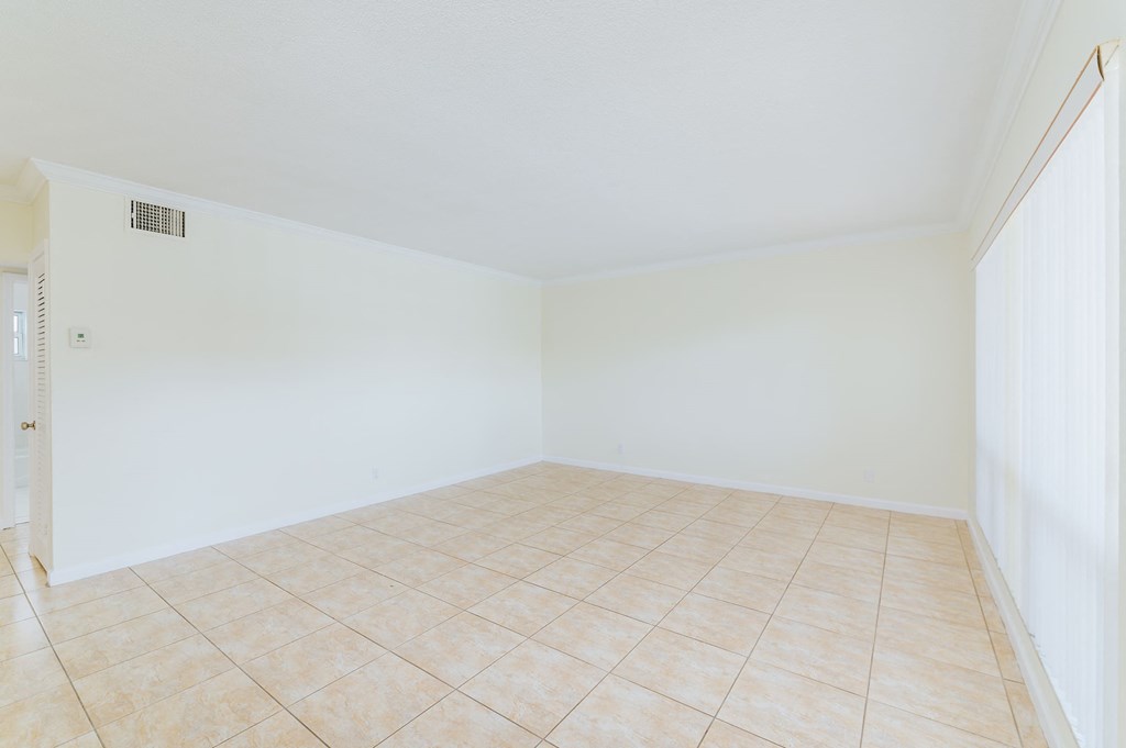 an empty room with a tiled floor and white walls