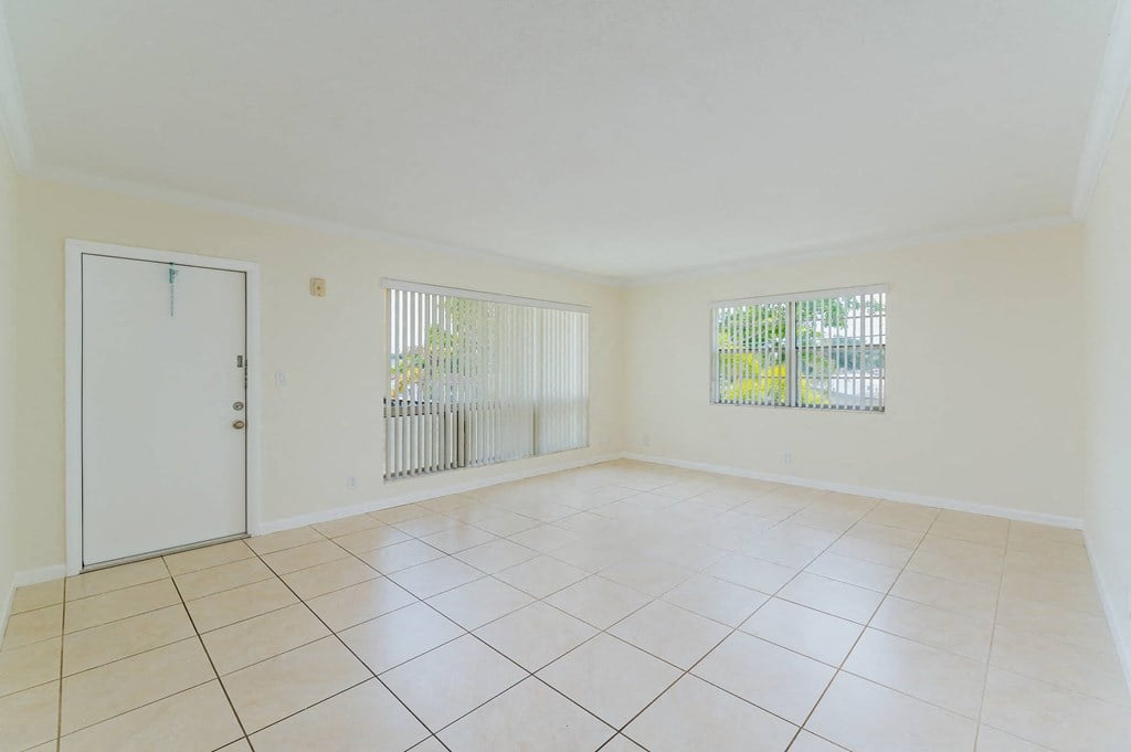 the spacious living room has tiled flooring and a door to the balcony