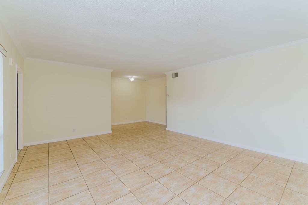the living room and dining room of an empty house with tile flooring