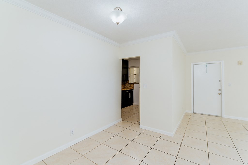 a room with a tiled floor and a door to a kitchen