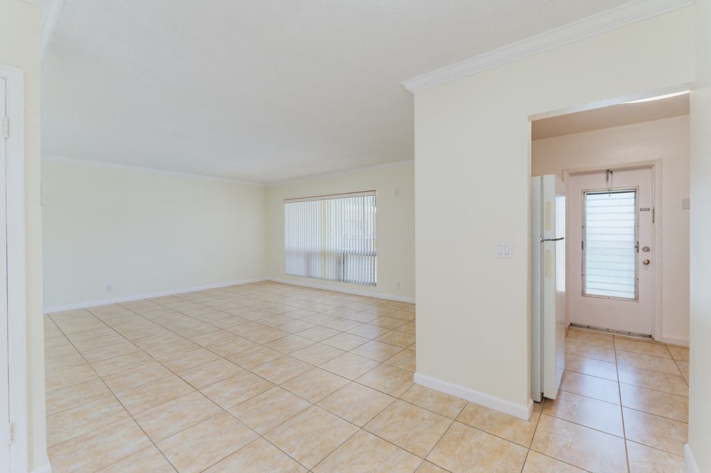 the living room and dining room of a house with a tiled floor