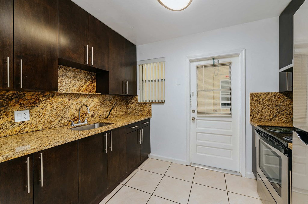 a kitchen with granite counter tops and a white door