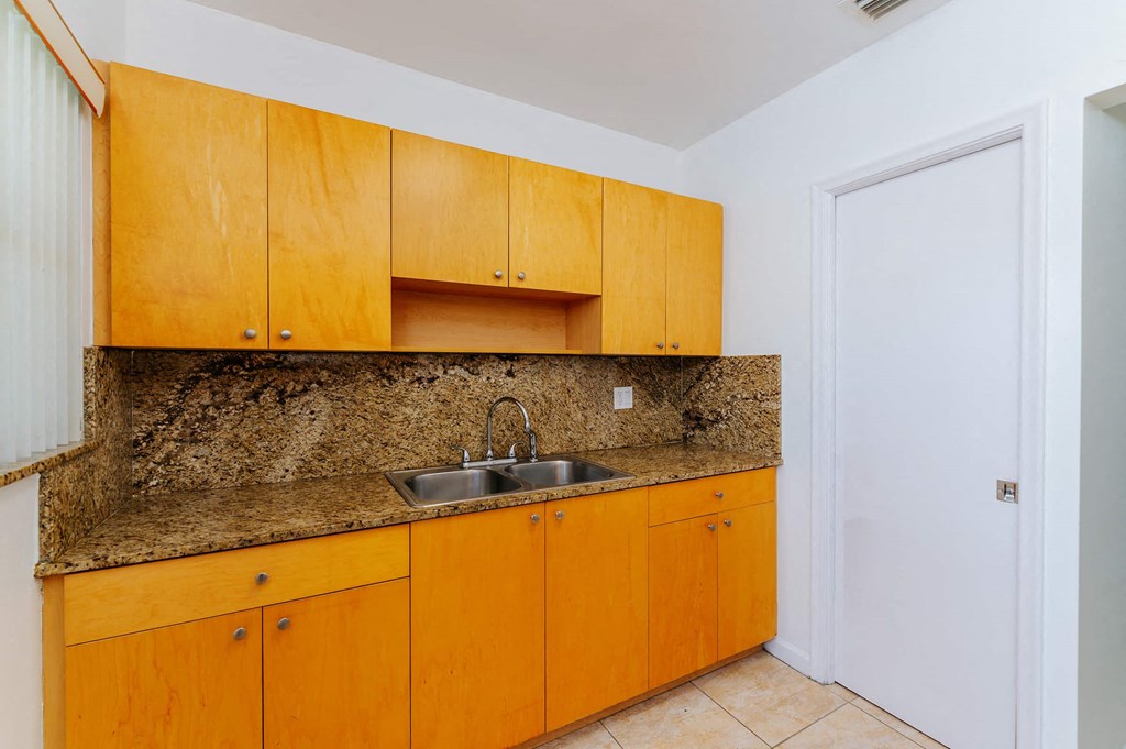 a kitchen with a granite counter top and wooden cabinets