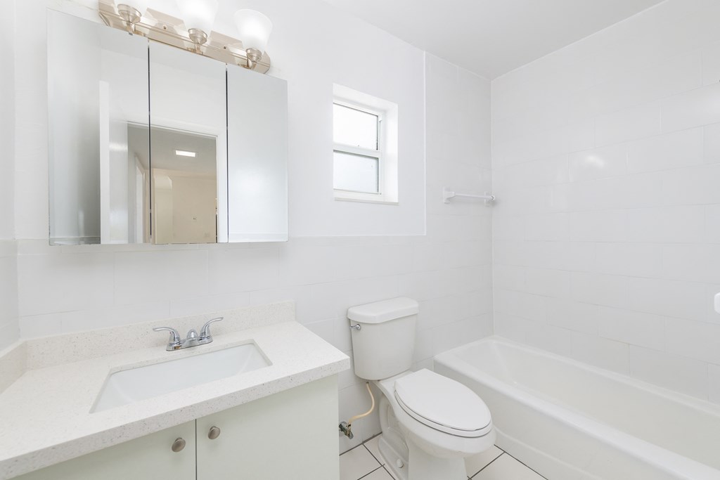 a white bathroom with a sink toilet and bath tub