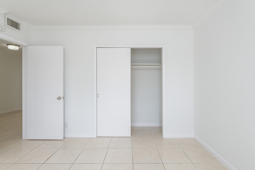 an empty room with three closet doors in it