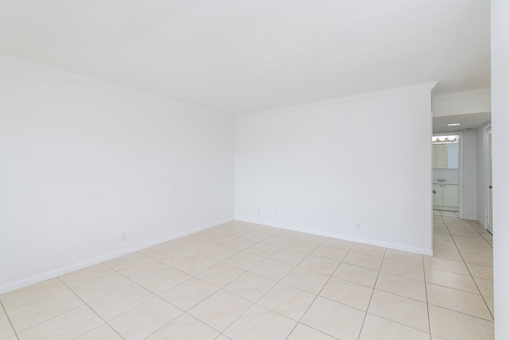 an empty room with a tiled floor and white walls