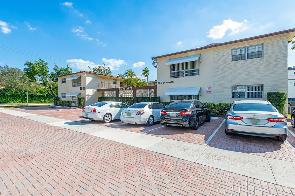 a parking lot with several cars in front of a building