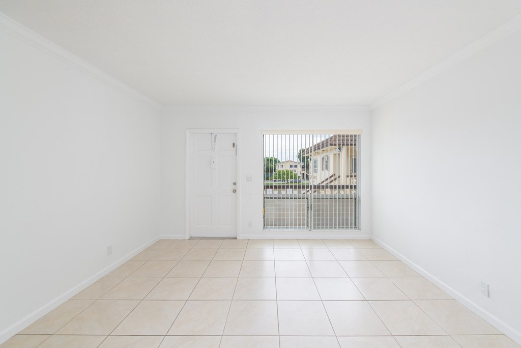 a clean and empty living room with a door to a balcony