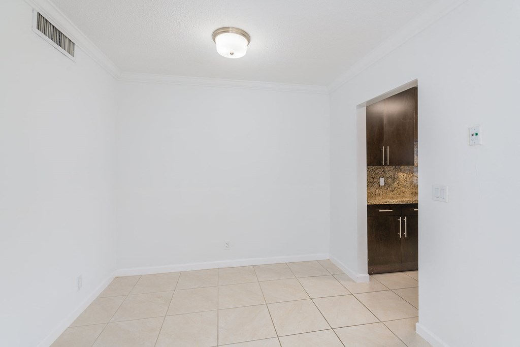an empty room with a sink and a door to a bathroom