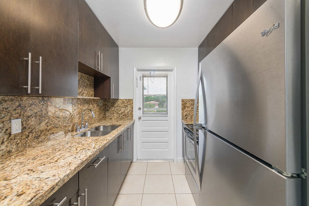 a kitchen with stainless steel appliances and marble counter tops