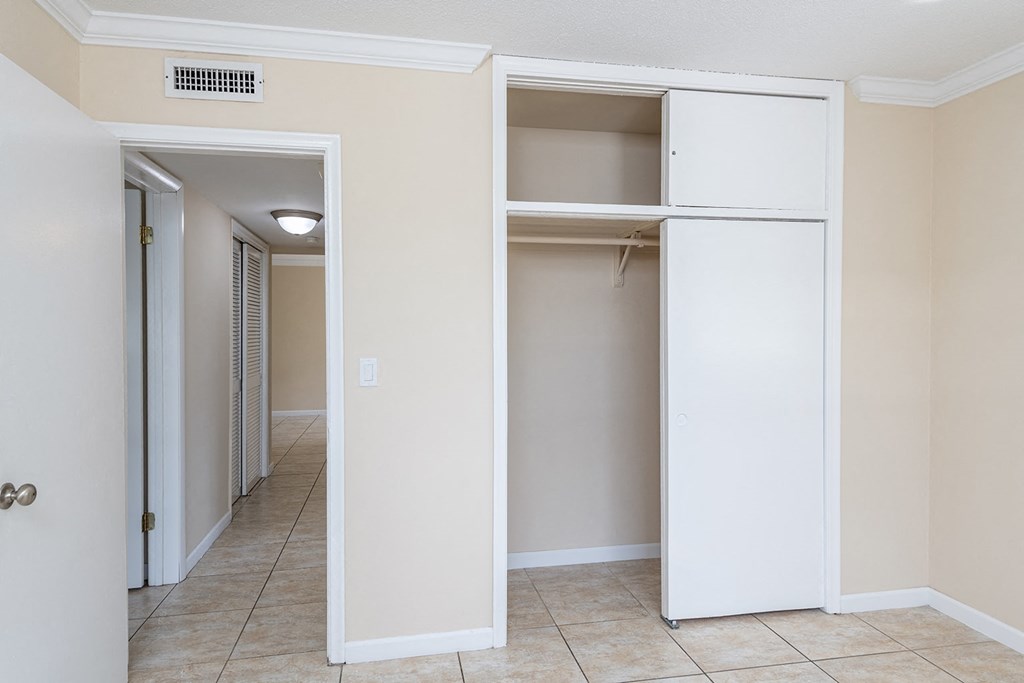 an empty closet in an empty room with a tiled floor