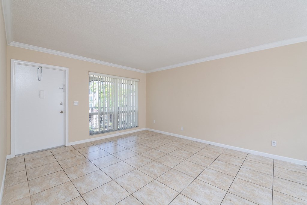 an empty living room with a door to a patio