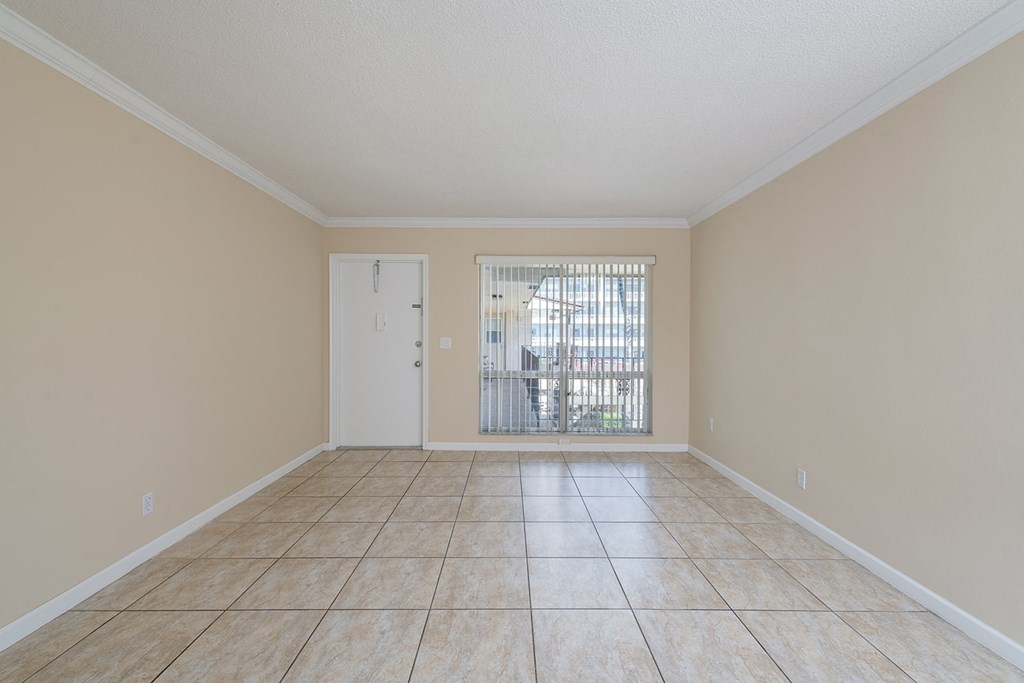 an empty living room with a door to a patio