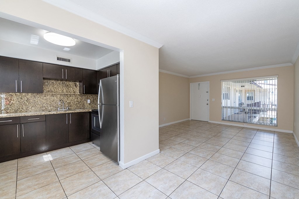 an empty kitchen with a stainless steel refrigerator