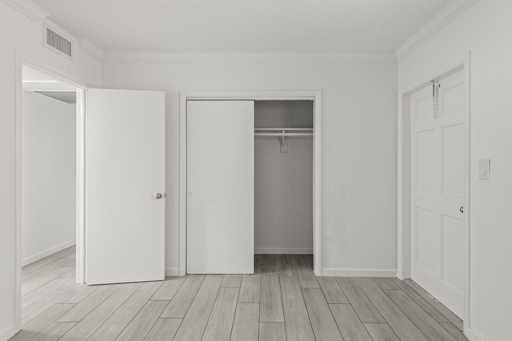 an empty room with white walls and a sliding closet