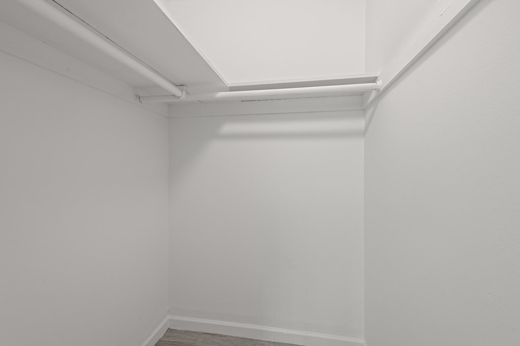 an empty room with white walls and a white fluorescent lamp on the ceiling