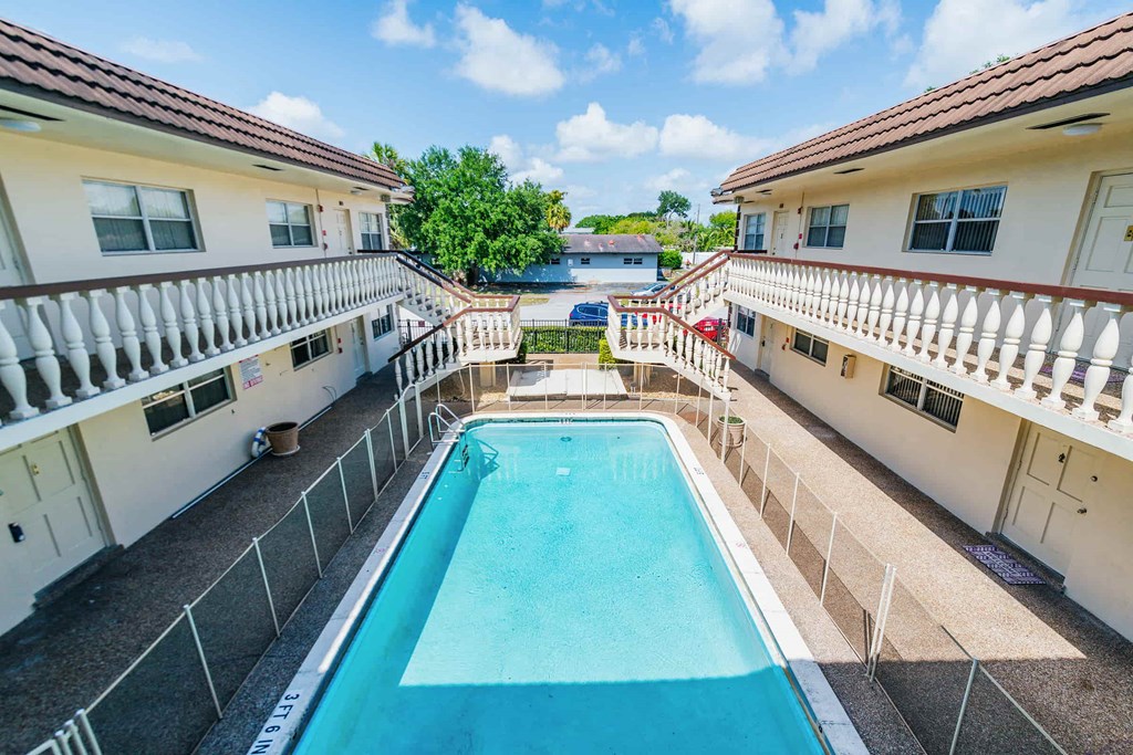 a swimming pool in the middle of two buildings with a pool