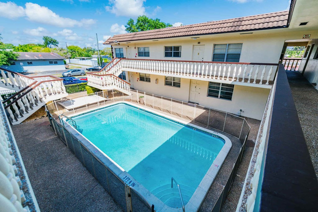 a swimming pool in front of a house with a pool