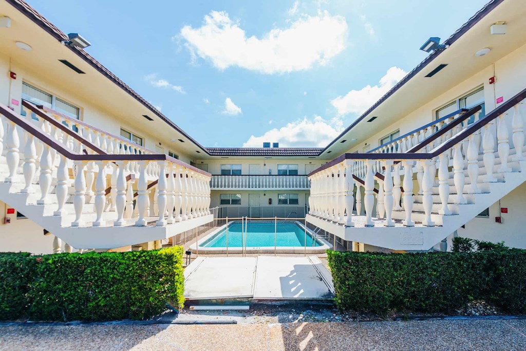 a building with a swimming pool and stairs next to it